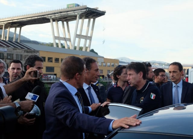 Italian Prime Minister Giuseppe Conte (second on the right) visits the site of the disaster scene after a section of the Morandi motorway bridge collapsed earlier in Genoa on August 14, 2018. Photo: Andrea Leoni / AFP